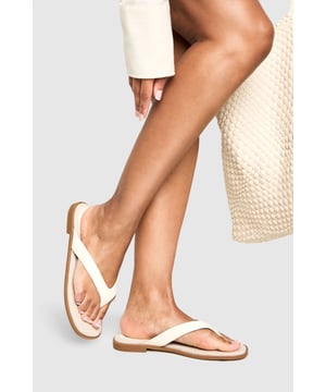 Wide fit design with chunky straps for enhanced comfort
        Flat heel measuring between 0-2cm for all-day wearability
        Toe post style with smooth PU upper for a contemporary look
        Cushioned footbed providing essential support
        Versatile neutral tone that complements any summer outfit
    
    These wide fit flip-flops with chunky straps offer the perfect blend of style and comfort for your casual wardrobe. The minimalist design features a flat sole that keeps you grounded while the cushioned footbed ensures your feet stay comfortable throughout the day. Style these versatile sandals with a flowing maxi dress and oversized tote bag for a relaxed beach day, or pair with cropped linen trousers and a loose-fitting blouse for weekend brunches. The clean lines and contemporary silhouette make these flip-flops an essential addition to your holiday packing list - ideal for poolside lounging or casual strolls along the promenade. Their understated elegance allows them to transition effortlessly from daytime errands to casual evening gatherings, making them a truly versatile summer staple that will serve you well throughout the warmer months.