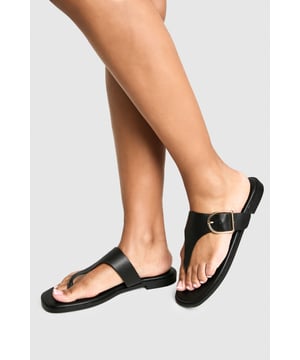Wide fit design for enhanced comfort and all-day wearability
        Distinctive gold-tone buckle detail adds a touch of sophistication
        Flat heel measuring between 0-2cm provides excellent stability
        Toe post style with smooth PU straps for minimal friction
        Sleek, minimalist silhouette perfect for versatile styling
    
    These wide fit flip-flops combine practicality with contemporary style, featuring an elegant buckle detail that transforms a casual essential into something rather special. The flat design ensures comfort for extended wear, whether you're strolling along the beach or navigating city streets. Style them with cropped wide-leg trousers and an oversized linen shirt for a relaxed daytime look, or pair with a flowing maxi dress for casual garden parties. Their understated design makes them ideal for holiday packing, working seamlessly from poolside lounging to impromptu caf visits. The wide fit construction offers additional comfort for those requiring a bit more room, whilst maintaining the clean, unfussy aesthetic that's characteristic of the Boohoo brand. These sandals effortlessly bridge the gap between casual comfort and considered style.