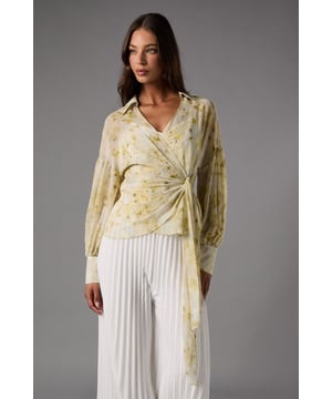 Elegant chiffon wrap design with sophisticated side tie detail
        Flattering V-neckline to showcase delicate jewellery
        Voluminous balloon sleeves with fitted cuffs for dramatic effect
        Lightweight, flowing fabric with delicate print throughout
        Versatile cropped length perfect for high-waisted bottoms
    
    This exquisite Coast wrap top embodies refined occasion dressing with its graceful silhouette and thoughtful details. The lightweight chiffon creates a beautifully draped effect, while the wrap design with side tie accentuates the waist for a figure-flattering finish. Style with the pleated wide-leg trousers as shown for a sophisticated ensemble perfect for summer weddings or race day events. For evening occasions, pair with a tailored pencil skirt and strappy heels, adding statement earrings to complete your look. The versatile design transitions effortlessly from formal gatherings to elegant dinner parties, making it a wardrobe essential for the discerning woman who appreciates timeless elegance with contemporary flair. The balloon sleeves add a touch of drama whilst maintaining an overall refined aesthetic suitable for the most prestigious events.