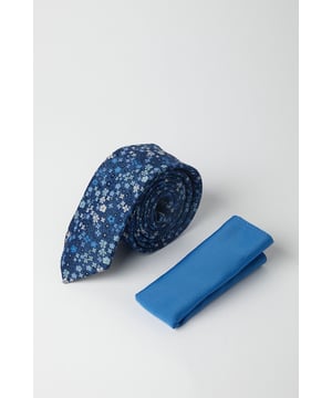 Woven tie featuring an intricate ditsy floral pattern throughout
        Complementary solid pocket square in a matching blue hue
        Slim profile tie design for a contemporary silhouette
        Versatile accessory set that adds a refined touch to formal attire
        Perfect for creating a coordinated look with minimal effort
    
    Add a touch of sophistication to your formal ensemble with this stylish Burton tie and pocket square set. The navy tie showcases a delicate ditsy floral pattern that brings subtle visual interest to your outfit without overwhelming it. As shown on our model, pair with a crisp white shirt and grey suit for a classic look that works brilliantly for important meetings or special occasions. The solid pocket square offers the perfect complement, allowing you to create a cohesive appearance with minimal fuss. This versatile set transitions seamlessly from daytime office wear to evening functions, making it an essential addition to your smart wardrobe. Whether you're attending a wedding, heading to an important presentation, or simply want to sharpen up your pub lunch attire, this thoughtfully designed accessory set delivers understated British elegance.