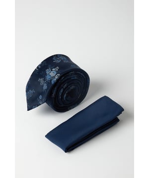 Woven tie featuring an elegant floral pattern throughout
        Matching solid pocket square for coordinated sophistication
        Classic width tie suitable for formal and business occasions
        Versatile navy base that pairs effortlessly with various suit styles
        Subtle textured finish adds depth and visual interest
    
    This Burton tie and pocket square set delivers understated refinement for the modern gentleman. The navy floral design strikes the perfect balance between classic and contemporary, making it an essential addition to your formal wardrobe. As shown, pair with a crisp white shirt and grey three-piece suit for business meetings or special occasions. The coordinated pocket square can be styled in multiple ways-try a classic peak fold for traditional events or a puff fold for a more relaxed gathering at the pub with mates. This versatile set transitions seamlessly from daytime office wear to evening functions, ensuring you're always appropriately dressed with minimal effort. Perfect for weddings, interviews, or any occasion where you want to convey confidence and attention to detail without appearing overdressed.