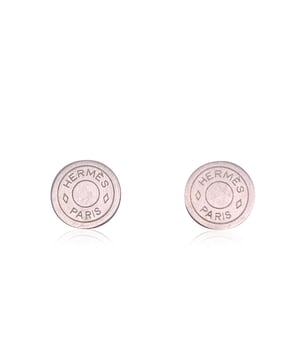 VINTAGE, RRP AS NEW
Discover the understated elegance of these vintage Hermes silver metal round 'Clou de Selle' clip-on earrings. With a sleek and minimalist design, these 20mm diameter earrings feature the iconic Clou de Selle motif, a symbol of the house's equestrian heritage.  Their matte silver finish and clean lines make them versatile enough to complement any ensemble, while their clip-on style ensures comfort without sacrificing style. Engraved with 'Hermes Paris - Bijouterie Fantaisie' on the back, these earrings reflect the exquisite craftsmanship that defines Hermes. A perfect blend of classic sophistication and timeless appeal, they are a coveted piece for any vintage jewelry enthusiast or discerning collector. Condition Rating: B - VERY GOOD CONDITIONCondition Details: Light scratches on the earrings, on th front and on the back. Please, look carefully at the photos and ask for any detail.  Box?: ?: No