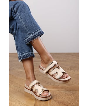 Add a touch of glamour to your casual looks with these Splendor Slider Flatform Sandals With Cutout Straps. Featuring textured woven panels and metallic gold trims, they combine comfort and sophistication in one easy slide-on style. The cushioned footbed and elevated sole provide support with a fashionable edge. Perfect for day-to-night wear, holidays, or city strolls. Key Features: • Material: Woven textile and faux leather upper with padded insole • Design: Wide-cut slide with cut-out detailing and gold metallic trim • Closure: Slip-on style for ease and comfort