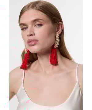 Make a captivating entrance with these Karen Millen Pearl And Tassel Detail Statement Earrings. The opulent combination of delicate pearls and flowing tassels creates a dramatic silhouette that demands attention. Perfect for formal occasions, these earrings add instant glamour to evening gowns and cocktail dresses alike. Style with an elegant updo to showcase their full length, or wear with sleek, straight hair for a contemporary contrast. The versatile design works with both strapless necklines and high-neck ensembles. For wedding guest attire, pair with a tailored jumpsuit and minimal additional jewellery to let these showstoppers take centre stage. These statement pieces transition effortlessly from daytime events to evening soires, adding a touch of sophistication to any ensemble.  Statement earrings featuring pearl detailing and tassel embellishment Post fastening for secure and comfortable wear Cascading design