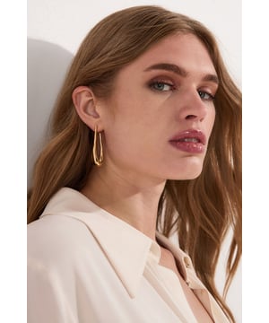 These Karen Millen Drop Hoop Earrings offer a modern interpretation of classic hoops with their sophisticated teardrop shape. The smooth, curved design creates a fluid look that moves gracefully with every turn of the head. Their versatility shines through when matched with both daytime and evening attire; complement a sleek ponytail for daytime elegance or let them take centre stage with swept-back hair at weddings and special events. The understated yet distinctive design makes these earrings the perfect finishing touch for race day ensembles or graduation ceremonies, adding a touch of refinement without competing with your outfit.  Elongated drop hoop design with a contemporary twist Polished metallic finish Secure post fastening Distinctive teardrop silhouette