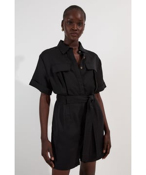 This Karen Millen playsuit combines effortless style with practical design for versatile daywear. The woven viscose linen fabric offers a natural texture and comfortable feel, perfect for warmer days. The belted waist creates a feminine shape while the collared neckline maintains a smart edge. Layer with a lightweight cardigan when the temperature drops, or add a crossbody bag for hands-free convenience during city explorations. This playsuit transitions seamlessly from shopping trips to alfresco dining, making it an essential addition to your warm-weather wardrobe.  Crafted from a viscose linen blend Classic collared neckline with button-through front design Short sleeves with neat cuffs Practical chest pockets Matching fabric belt