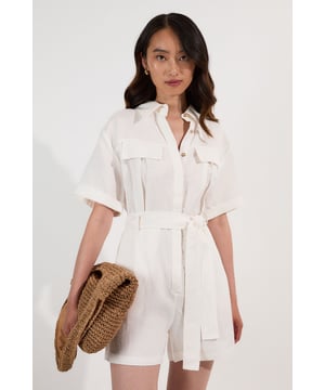 This Karen Millen playsuit combines effortless style with practical design for versatile daywear. The woven viscose linen fabric offers a natural texture and comfortable feel, perfect for warmer days. The belted waist creates a feminine shape while the collared neckline maintains a smart edge. Layer with a lightweight cardigan when the temperature drops, or add a crossbody bag for hands-free convenience during city explorations. This playsuit transitions seamlessly from shopping trips to alfresco dining, making it an essential addition to your warm-weather wardrobe.  Crafted from a viscose linen blend Classic collared neckline with button-through front design Short sleeves with neat cuffs Practical chest pockets Matching fabric belt