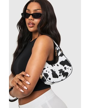 Distinctive cow-print design for a bold statement accessory
        Compact crescent shape with single shoulder strap
        Gold-tone hardware accents for a luxe finish
        Secure zip closure to keep essentials safe
        Versatile size perfect for nights out
    
    Make a fashion statement with this eye-catching cow-print bag that's sure to turn heads on your next night out. The trendy crescent silhouette sits comfortably under your arm whilst the adjustable shoulder strap offers practical versatility. Pair with a sleek black ensemble as shown for maximum impact, or use it to add a playful touch to any monochrome outfit. The compact yet practical size makes it ideal for carrying your essentials when hitting the club or meeting friends for drinks. The striking pattern works brilliantly against both casual and dressed-up looks - try styling with a little black dress and strappy heels for an evening at the bar, or with jeans and a crop top for a more relaxed approach to urban nightlife. This Boohoo bag delivers the perfect blend of fun and functionality for the fashion-forward partygoer.