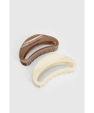 Set of two oversized hair claws in complementary neutral tones
        Curved design with textured teeth for secure grip
        Generous size perfect for thick or voluminous hair
        Sleek, minimalist aesthetic suitable for everyday wear
        Versatile styling accessory for effortless updos and half-up styles
    
    These oversized hair claws offer the perfect blend of function and fashion for your everyday hair styling needs. The curved, ergonomic shape works beautifully to create casual updos with minimal effort - simply twist your hair and secure with the claw for an instant polished look. The textured teeth provide excellent grip without snagging or pulling, making these claws ideal for all hair types. Style yours with a casual jumper and jeans for daytime errands, or use them to create a sleek bun for more formal occasions. The neutral tones ensure these accessories will complement any outfit in your wardrobe. For a trendy look as seen on our model, try a relaxed half-up style with loose tendrils framing your face - the perfect low-maintenance option for busy days when you still want to look put-together.