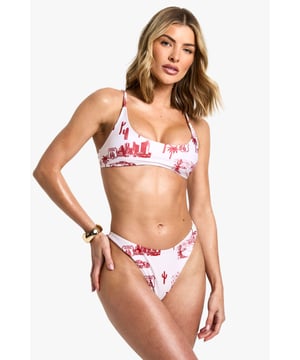 Striking moto-print bikini featuring a bold cityscape and palm tree design
        Flattering scoop neckline top with adjustable spaghetti straps for a customised fit
        Tie-back fastening allows for secure and comfortable wear
        High-cut briefs with a cheeky rear for a contemporary silhouette
        Lightweight swim fabric that dries quickly for all-day beach comfort
    
    Make a statement poolside with this eye-catching moto-print bikini from Boohoo. The scoop neckline offers just the right amount of coverage whilst maintaining a fashion-forward look that's perfect for soaking up the sun. Style with oversized sunglasses and a wide-brimmed hat for ultimate holiday glamour, or layer under a sheer beach dress when heading from the pool to beachside cocktails. The high-cut briefs create a leg-lengthening effect that's both flattering and on-trend. This versatile two-piece works brilliantly for everything from lounging by the pool to beach volleyball with friends. Complete your look with metallic accessories and a lightweight kimono for those sunset beach walks. The perfect addition to your holiday wardrobe that will have you standing out for all the right reasons.
