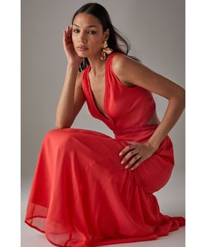 Flowing chiffon maxi dress with delicate fringe trim detailing
        Striking plunge neckline creates a feminine silhouette
        Elegant cut-out back design with tie fastening for adjustable fit
        Tiered skirt construction with gathered waist for added movement
        Fully lined for comfort and opacity while maintaining the lightweight feel
    
    Make a statement in this captivating chiffon maxi dress from Warehouse. The striking plunge neckline frames the dcolletage beautifully, while the cut-out back detail adds an unexpected twist to this flowing piece. The delicate fringe trim and tiered construction create movement with every step, making it perfect for garden parties or summer soires. Style with metallic strappy heels and statement earrings as seen on our model for evening events, or dress down with flat sandals and a woven clutch for daytime gatherings. The lightweight fabric drapes elegantly around the figure, creating a relaxed yet refined silhouette that works wonderfully for warm-weather occasions. This versatile dress transitions effortlessly from casual family gatherings to more formal events with the right accessories.