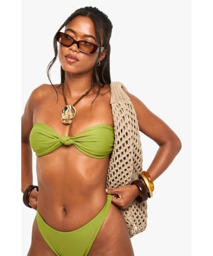 Strapless bandeau design with stylish front twist detail
        Smooth, stretchy fabric with elastane for comfortable fit
        Coordinating high-leg bikini bottoms for a flattering silhouette
        Fully lined for confidence and comfort in and out of water
        Versatile design perfect for mixing and matching with other swimwear pieces
    
    Make a statement poolside with this chic bandeau bikini top from Boohoo's Swimwear Essentials collection. The distinctive twist-front detail adds interest to the classic strapless design, whilst the stretchy fabric ensures a secure and comfortable fit that moves with you. Style with the matching high-leg bottoms for a coordinated beach look, or mix with printed alternatives for a personalised touch. Complete your resort ensemble with oversized sunglasses and a woven beach bag as seen on our model. This versatile bikini works brilliantly for everything from lounging by the pool to beach volleyball, and transitions effortlessly to beachside bars when paired with a flowing kimono and metallic sandals. The perfect addition to your holiday wardrobe for those sun-soaked getaways.
