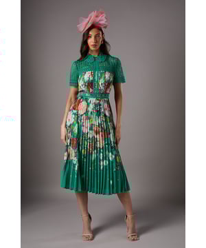 Exquisite lace collar and short sleeves for a touch of sophistication
        Stunning floral print on a pleated midi skirt for graceful movement
        Fitted waistband accentuates the silhouette
        Intricate lace detailing on the bodice adds texture and elegance
        Versatile midi length suitable for various formal occasions
    
    This enchanting lace pleated midi dress radiates charm and refinement, perfect for those seeking a statement piece for special events. The delicate lace collar and short sleeves provide a sophisticated frame for the dcolletage, while the vibrant floral print adorning the pleated skirt creates a captivating visual impact. Ideal for weddings, race days, or summer garden parties, this dress offers versatility in styling. Pair it with strappy heeled sandals and a fascinator for a classic race day ensemble, or opt for elegant court shoes and a clutch for a wedding guest look. The fitted waistband emphasises your figure, while the flowing pleated skirt ensures comfort and grace as you move. Accessorise with drop earrings to complement the dress's inherent elegance, and consider a wrap or tailored blazer for cooler evenings. This Coast creation embodies timeless sophistication, guaranteeing you'll stand out at any formal gathering.