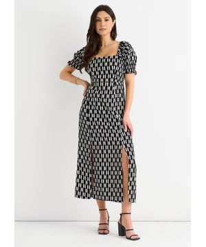 Maak een modern statement in deze zwart-witte midi-jurk met geometrische print. Ontworpen met een flatterende vierkante halslijn en volumineuze pofmouwen, combineert het klassieke elegantie met een eigentijds randje. Het geribbelde lijfje loopt over in een licht uitlopende rok, met dubbele splitten aan de voorkant om nog meer te flatteren. Dit veelzijdige stuk is perfect om van dag tot avond te dragen en past moeiteloos bij hakken voor een chique, zelfverzekerde look.