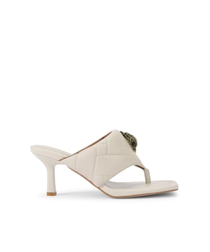 This Kurt Geiger pair of Puff Heeled Sandals feature a bone leather upper with padded overstitch quilting across the t-bar straps. There is an antiqued brass eagle head sat on top of the straps. Heel height: 7cm.