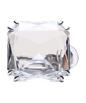 Der Mesmera Cry Square Einzelohrring 5600756 ist ein origineller transparenter Kristall-Ohrclip mit quadratischer Form.\n Wird einzeln verkauft und sein großer Kristall im Trillion-Schliff stiehlt die Show.\n Es kann alleine getragen oder mit anderen Designs für skurrile und lustige Kombinationen kombiniert werden!\n Designerin: Giovanna Engelber\n Maßnahmen: Abmessungen: 2,4 x 2,4 cm.\n Komposition: Kristall, rhodiniert\n Pflege:\nVermeiden Sie den Kontakt mit Cremes, Parfüms und Reinigungsmitteln, die das Produkt beschädigen könnten. Um den Glanz zu erhalten, empfehlen wir Ihnen, es nur mit einem weichen Tuch zu reinigen.