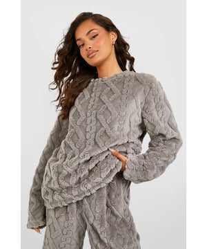 Luxurious cable knit fleece texture for ultimate comfort
        Relaxed fit sweatshirt with dropped shoulders for effortless style
        Ribbed crew neckline and cuffs for a snug fit
        Coordinating wide-leg trousers for a complete lounge set
        Versatile design suitable for both indoor relaxation and casual outings
    
    Embrace cosy chic with this Cable Knit Fleece Lounge Sweatshirt from Boohoo. Perfect for those lazy days at home or casual weekend brunches, this sweatshirt combines style and comfort effortlessly. The intricate cable knit pattern adds a touch of sophistication to your loungewear collection, while the soft fleece fabric ensures you stay warm and snug. Pair it with the matching wide-leg trousers for a coordinated look, or style it with your favourite jeans for a quick coffee run. Add some statement earrings and slip-on trainers to elevate the outfit for impromptu catch-ups with friends. Whether you're binge-watching your favourite series or hosting a laid-back gathering, this versatile piece will keep you looking put-together while feeling utterly relaxed.