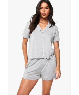 Classic button-through shirt with notched collar for a sophisticated nightwear look
        Short sleeves with neat cuffed detailing for a polished finish
        Relaxed fit shorts with comfortable elasticated waistband
        Soft jersey fabric that drapes beautifully for ultimate comfort
        Coordinated two-piece set that can be worn together or separately
    
    Embrace bedtime bliss with this chic short-sleeved shirt and shorts set from Boohoo. The traditional shirt styling brings a touch of refinement to your nightwear collection, whilst the relaxed fit ensures maximum comfort for a restful night's sleep. Perfect for warm summer evenings or cosy nights in, this versatile set works brilliantly for lounging about on lazy weekend mornings with a cup of tea and your favourite book. The matching set offers effortless style without compromising on comfort, making it ideal for those impromptu doorstep deliveries or quick dashes to the kitchen. For cooler nights, simply pair with fluffy socks or layer with a lightweight dressing gown. This nightwear essential reflects Boohoo's commitment to creating fashion that's both accessible and on-trend, ensuring you look stylish even when you're winding down.