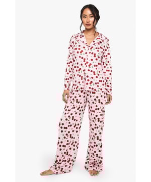 Soft touch cotton fabric for ultimate comfort during sleep
        Classic button-through shirt design with notched collar
        Playful cherry print pattern throughout the set
        Relaxed fit long-sleeve top with matching wide-leg trousers
        Full-length design offering complete coverage for cooler nights
    
    Drift into dreamland in style with this charming cherry-print pyjama set from Boohoo. The soft touch cotton fabric feels wonderfully gentle against the skin, making it perfect for those nights when comfort is your top priority. The traditional shirt-style top features a smart notched collar and button-through front, whilst the wide-leg trousers create a relaxed silhouette that allows for easy movement throughout the night. This set strikes the perfect balance between cute and comfortable - ideal for lazy weekend mornings with a cup of tea and your favourite book, or for lounging about on chilly evenings. The timeless design ensures this set will remain a bedtime favourite season after season, whilst the playful print adds a touch of fun to your nightwear collection.