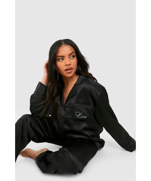 Luxurious satin fabric for ultimate comfort
        Stylish diamante detailing adds a touch of glamour
        Relaxed-fit trousers for unrestricted movement
        Button-up shirt with long sleeves for versatile wear
        Chic embroidered 'Love' detail on the chest pocket
    
    Indulge in the perfect blend of comfort and style with this satin diamante detail pyjama trouser set. The smooth, lustrous fabric caresses your skin, ensuring a restful night's sleep. The relaxed-fit trousers allow for easy movement, while the long-sleeved button-up shirt offers versatility for those lazy weekend mornings. The subtle diamante embellishments add a touch of sparkle, making you feel fabulous even in your downtime. Whether you're settling in for a cosy night or enjoying a leisurely breakfast in bed, this set strikes the ideal balance between relaxation and sophistication. Pair with soft slippers and a plush dressing gown for the ultimate loungewear ensemble, or wear the shirt with your favourite jeans for a chic, off-duty look that transitions seamlessly from night to day.