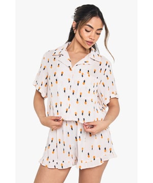 Playful pineapple print shirt and shorts set for stylish nightwear
        Relaxed short-sleeve button-up shirt with classic collar
        Comfortable loose-fitting shorts with elasticated waistband
        Lightweight woven fabric for breathable comfort
        Versatile two-piece design perfect for lounging and sleeping
    
    Bring a touch of tropical charm to your nightwear collection with this delightful pineapple print shirt and shorts set from Boohoo. The relaxed silhouette offers unrestricted movement whilst maintaining a fashionable edge that makes bedtime something to look forward to. Style with fluffy slippers for cosy nights in, or throw on the shirt with your favourite denim shorts when the temperature rises for an effortless daytime look. The breathable woven fabric ensures comfort throughout the night, whilst the playful print adds personality to your sleepwear rotation. Perfect for summer evenings, weekend getaways, or simply lounging at home with a good book and a cup of tea. This set strikes the ideal balance between comfort and style, ensuring you look just as good as you feel when winding down for the evening.
