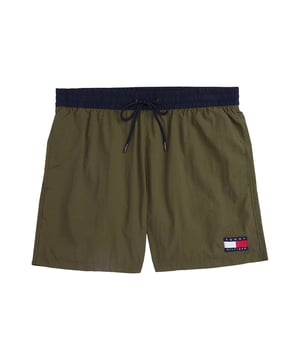 Diese Herren-Badeshorts im Slim Fit überzeugen mit sportlicher Eleganz und passgenauem Sitz. Der oberschenkellange Schnitt betont die Figur und bietet dennoch volle Bewegungsfreiheit. Ein farblich abgesetzter Bund mit Tunnelzug setzt einen frischen Akzent und sorgt für sicheren Halt. Seitliche Eingrifftaschen und eine Gesäßtasche bieten praktische Verstaumöglichkeiten. Der elastische Bund passt sich flexibel an – ideal für aktive Tage am Wasser. Der leichte Stoff trocknet schnell und trägt sich auch nach dem Schwimmen angenehm. Ein dezenter Label-Aufnäher am Bein rundet das Design markant ab. Diese Shorts machen am Strand ebenso eine gute Figur wie auf der Promenade. Schmal geschnitten, aber maximal bequem. Für Männer, die auf Stil auch beim Baden nicht verzichten möchten.