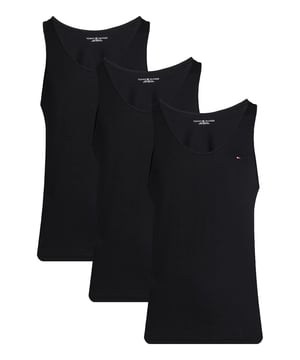 Dieses Herren-Tanktop im praktischen 3er Pack ist ein echtes Essential für warme Tage und sportliche Aktivitäten. Der klassische Rundhalsausschnitt sorgt zusammen mit dem Regular Fit für eine angenehme, lässige Passform. Hals- und Ärmelausschnitte sind mit einer robusten Rippblende versehen, die für Formstabilität und einen sportlichen Look sorgt. Eine kleine Logo-Stickerei auf der Brust setzt einen dezenten, stilvollen Akzent. Das weiche, atmungsaktive Material liegt angenehm auf der Haut und bietet höchsten Tragekomfort – den ganzen Tag. Ob als Basic unter dem Hemd oder solo zur Shorts, dieses Tanktop macht immer eine gute Figur. Es bietet maximale Bewegungsfreiheit und ist ideal für Freizeit, Sport oder einfach zum Relaxen. Die hochwertige Verarbeitung garantiert Langlebigkeit, auch nach vielen Waschgängen. Klare Linien, zeitloses Design – mehr braucht es nicht. Für Männer, die Wert auf Komfort und Qualität legen.