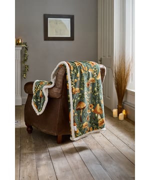Bring a touch of woodland wonder to your home with the Deyongs Mushroom Throw in soothing sage. This beautifully detailed throw features a vibrant print of golden mushrooms and wildflowers set against a leafy green background, capturing the magic of a forest floor in autumn. The velvety 220gsm flannel front offers a smooth, soft finish, while the 200gsm sherpa reverse adds a plush, warming layer—perfect for snuggling up. Sized at 140x180cm and made from 100% polyester, it’s durable, machine washable, and ideal for adding cozy, whimsical charm to any space.