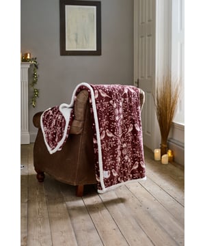 Embrace the cosy charm of the season with the Deyongs Winter Birds Throw in rich burgundy. Adorned with a delicate pattern of birds, pinecones, and winter foliage, this throw adds a festive yet elegant touch to your home. The velvety 220gsm printed flannel front feels silky smooth, while the 200gsm sherpa reverse provides a luxuriously soft and warm layer—perfect for chilly days and nights. Measuring 140x180cm and made from 100% polyester, it’s both practical and stylish, offering machine-washable convenience and timeless seasonal appeal.