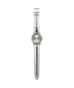 Devota & Lomba California Silver Watch: brillante Eleganz mit urbaner Seele.\n\n Diese Uhr wurde für Frauen entworfen, die Wert auf raffinierten Stil mit modernen Akzenten legen. Sie besticht durch ihr metallisches Finish und das subtile Spiel der Swarovski-Kristalle auf dem Zifferblatt. Ein funktionales Accessoire mit anspruchsvollem Flair.\n\n Details:\n - 30 mm rundes Stahlgehäuse, umgeben von Swarovski-Kristallen.\n - Minimalistisches Zifferblatt mit Swarovski-Kristallen im Inneren.\n - Japanisches Quarzwerk PC32.\n - Echtes Lederarmband mit silbernem Metallic-Finish.\n - Wasserdicht bis 5 ATM.\n\n Eine feminine, funktionale und charaktervolle Uhr, die jeden Look mit einem Hauch von Raffinesse aufwertet.\n Maßnahmen: 35 mm\n Komposition: Haut, Metall\n Pflege:\nVermeiden Sie den Kontakt mit Parfüms, Cremes oder Chemikalien.