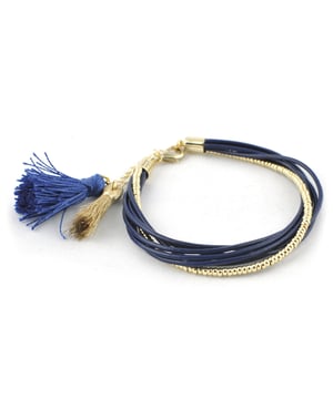 Pulsera Santorini: estilo mediterráneo con textura y carácter.\n\nEsta pulsera de inspiración bohemia combina cuero en tono marino con detalles metálicos dorados y borlas decorativas, creando una pieza con movimiento, frescura y personalidad. Un diseño multihilos que resalta por su dinamismo y acabado artesanal.\n\nDetalles:\n- Elaborada con tiras de piel combinadas con cuentas metálicas.\n- Acabado dorado en los elementos metálicos para un toque sofisticado.\n- Cierre de mosquetón.\n- Borlas textiles decorativas que añaden movimiento y color.\n- Diseño multihilos con mezcla de texturas y tonos contrastantes.\n\nUna pulsera desenfadada y original, perfecta para looks estivales, urbanos o con influencia boho chic.\n Medidas: Diámetro: 7 cm\n Composición: Piel, Metal, Textil\n Cuidados:\nEvitar el contacto con agua, perfumes o productos abrasivos.