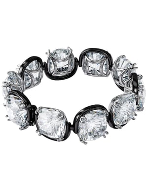 Dieses Manschettenarmband vereint Geheimnis und Extravaganz und erzeugt die Illusion, als würden seine Steine schweben. Es ist fachmännisch aus einer Reihe übergroßer, klarer Kristalle im Kissenschliff in einer eleganten Krappenfassung gefertigt. Kombinieren Sie es mit eleganten schwarzen Abendhandschuhen oder einem schlichten Langarm-T-Shirt, um Ihren Tageslook zu unterstreichen. Dieses Armband, das Teil der Harmonia-Familie ist, wurde von Kreativdirektorin Giovanna Engelbert für die Kollektion I entworfen. So schließen und öffnen Sie: Platzieren Sie den Riegel mit dem runden Ende an der breitesten Stelle der gegenüberliegenden Lücke und schieben Sie ihn bis zur schmalsten Stelle Lücke. Sobald es angebracht ist, senken Sie den Sicherheitsverschluss oben ab, um den Verschluss zu sichern. Zum Öffnen heben Sie den Sicherheitsverschluss an und schieben die Stange zum Lösen in den breiteren Spalt.\n Maßnahmen: Länge (Minimum – Maximum): 16,5 – 22,7 cm\n Breite: 1,7 cm\n Komposition: Material: Kristalle, verschiedene metallische Oberflächen\n Pflege:\nVermeiden Sie den Kontakt mit Cremes, Parfüms und Reinigungsmitteln, die das Produkt beschädigen könnten. Um den Glanz zu erhalten, empfehlen wir Ihnen, es nur mit einem weichen Tuch zu reinigen.