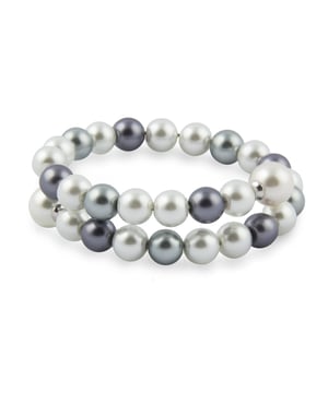 Pulsera Mallorca de Perlas de Mallorca: movimiento envolvente con estilo artesanal.\n\nEsta pulsera de doble vuelta combina perlas de Mallorca en distintas tonalidades, creando un diseño dinámico, elegante y lleno de armonía. Su estructura elástica permite una colocación fácil y un ajuste cómodo, sin renunciar a la sofisticación.\n\nDetalles:\n- Elaborada artesanalmente en Mallorca según el método tradicional.\n- Compuesta por perlas de Mallorca con acabado brillante y superficie pulida.\n- Diseño de doble vuelta con secuencia de tonos combinados para un efecto visual envolvente.\n- Estructura elástica resistente que se adapta a la muñeca con facilidad.\n- Sin cierre, cómoda de colocar y perfecta para uso diario.\n\nUna pulsera mujer versátil y moderna que conserva el alma clásica de la joyería mallorquina. Ideal para quienes buscan una pieza fácil de llevar, con personalidad y toques artesanales.\n Medidas: Diámetro: 60 mm\n Composición: Perlas\n Cuidados:\nEvitar el contacto con perfumes, cremas y productos químicos.