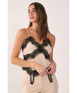 Elegant pinstripe design with luxurious lace trim detailing across the bodice
        Flattering strappy neckline with delicate shoulder straps for a feminine silhouette
        Striking contrast between the structured pinstripe fabric and soft lace embellishments
        Figure-enhancing tailored fit that contours to your shape
        Versatile piece that transitions effortlessly from day to evening wear
    
    Make a statement in this sophisticated Nasty Gal tailored strappy top that combines classic pinstripes with contemporary lace trim detailing. The contrasting textures create a captivating visual interest whilst the strappy neckline adds a touch of allure. Style with wide-leg trousers as shown for an elegant evening ensemble, or pair with high-waisted jeans and heels for drinks with the girls. The structured yet feminine design makes this top perfect for upscale bars and nightclubs. For cooler evenings, layer with a cropped blazer to maintain the sleek silhouette. Complete your look with statement earrings and a clutch bag for a night out that demands attention. This versatile piece works brilliantly for both intimate gatherings and livelier nightlife scenes.