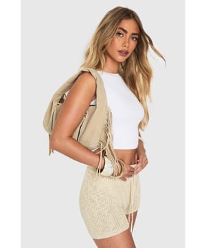 Faux suede hobo bag with statement fringe detailing along both sides
        Comfortable top handle design for easy carrying
        Practical zip closure to keep your essentials secure
        Stylish gold-tone hardware adding a touch of sophistication
        Spacious interior perfect for day-to-night essentials
    
    This boho-inspired faux suede bag brings effortless style to any outfit. The distinctive fringe detailing creates movement and texture, whilst the curved silhouette offers a relaxed yet fashionable aesthetic. Style with a fitted crop top and ribbed co-ord set for casual daytime outings, or pair with a flowing maxi dress and layered jewellery for evening drinks. The versatile design transitions seamlessly from office to dinner date, making it the perfect companion for busy days that turn into nights out. The practical size accommodates all your necessities without overwhelming your look, whilst the sturdy handle ensures comfortable carrying throughout the day. This Boohoo bag combines practicality with on-trend design for the fashion-forward woman.