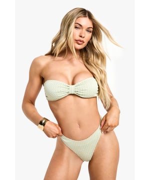 Textured knitted fabric with classic gingham pattern for a trendy retro vibe
        Bandeau-style top with elegant twist detail at centre front
        High-leg bikini bottoms for a flattering silhouette
        Strapless design perfect for minimising tan lines
        Secure back fastening ensures comfortable wear throughout the day
    
    Make a statement poolside with this charming gingham bikini from Boohoo. The bandeau top with its distinctive twist detail creates a flattering shape whilst the high-leg bottoms elongate your silhouette for maximum impact. Perfect for your next holiday, this bikini combines nostalgic charm with contemporary styling. Pair with oversized sunglasses and a wide-brimmed hat for classic riviera chic, or throw on a sheer cover-up and sandals for beachside lunches. The versatile design works brilliantly for both lounging by the pool and taking a refreshing dip. For evening beach parties, layer with a flowing maxi skirt and add statement jewellery to transition effortlessly from day to night. This bikini captures the essence of carefree summer days whilst ensuring you remain fashion-forward.