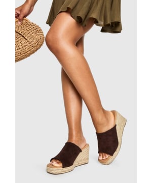 Chic suede mule espadrilles with comfortable mid-height wedge heel (5-6.5cm)
        Open toe design perfect for showcasing summer pedicures
        Traditional rope-wrapped wedge sole for authentic Mediterranean appeal
        Slip-on style for effortless wear and convenience
        Cushioned footbed providing all-day comfort and support
    
    These versatile Wildleder Espadrilles from Boohoo blend timeless Mediterranean charm with contemporary styling. The classic rope-wrapped wedge creates a flattering silhouette whilst maintaining walkable comfort with its mid-height design. Perfect for casual daytime events, these mules pair beautifully with flowing midi skirts and summer dresses as shown, or style with cropped trousers and a linen blouse for relaxed weekend brunches. The suede finish adds a touch of luxury to your everyday wardrobe, whilst the open-toe silhouette keeps your look fresh and seasonal. Complement with natural accessories like the woven handbag featured for a coordinated summer ensemble. These espadrilles transition effortlessly from family gatherings to beachside restaurants, offering both style and practicality for the fashion-forward woman who values versatility in her footwear collection.