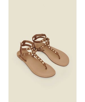 Consider your outfit elevated Crafted from the softest tan leather Timeless toe post silhouette Elevated with luxe gold studs Statement double strap design for a secure fit We're styling them with a white dress