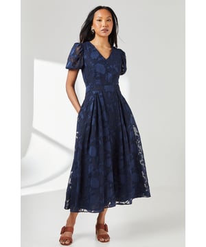 Elegant jacquard fabric with a subtle floral pattern
        Flattering V-neckline for a feminine touch
        Charming puff sleeves add a romantic flair
        Midi length perfect for various occasions
        Practical side pockets for convenience
    
    This enchanting midi dress from Principles is a versatile addition to your wardrobe, perfect for a range of daytime events. The jacquard fabric creates a luxurious texture, while the floral pattern adds a touch of whimsy. The V-neckline elongates the neck, and the puff sleeves bring a romantic element to the ensemble. The midi length is both practical and stylish, making it suitable for family gatherings or casual outings. Style this dress with strappy sandals and delicate jewellery for a relaxed lunch date, or pair it with ballet flats and a denim jacket for a day of shopping. The side pockets offer functionality without compromising on style. This dress is an ideal choice for those seeking a balance between comfort and elegance in their daywear.