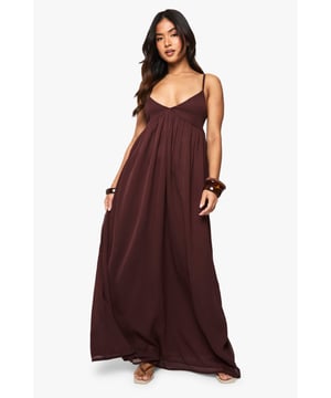 Flowing chiffon maxi dress designed specifically for petite frames
        Feminine strappy neckline with delicate spaghetti straps
        Empire waistline creates a flattering silhouette
        Relaxed, billowing skirt that offers effortless movement
        Floor-skimming length perfect for showcasing summer footwear
    
    This ethereal chiffon maxi dress from Boohoo combines comfort with effortless style for the fashion-forward woman. The empire waistline and strappy neckline create a beautifully feminine shape whilst the flowing fabric drapes gracefully to the floor, making it ideal for petite frames. Style with metallic sandals and wooden bangles for daytime gatherings, as seen on our model with her statement accessories. For cooler evenings, layer with a cropped denim jacket and add a woven clutch bag. This versatile piece transitions seamlessly from casual family brunches to sunset beach walks, offering the perfect balance of comfort and style. The lightweight chiffon fabric ensures you'll stay cool during warm-weather occasions whilst maintaining an air of casual sophistication.