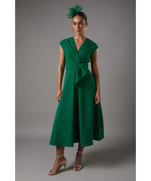 Elegant V-neckline for a flattering silhouette
        Wrap-style bodice with a cinched waist
        Striking belted detail with a rectangular buckle
        Cap sleeves for a graceful arm-flattering look
        Midi length with a flared A-line skirt
    
    This sophisticated belted crepe dress from Coast is the epitome of refined elegance. Perfect for those special occasions where you want to make a lasting impression, this dress combines timeless style with modern flair. The wrap-style bodice creates a flattering silhouette, while the belted waist accentuates your figure beautifully. The midi length and flared skirt offer a graceful movement as you walk, ideal for garden parties or summer weddings. Style it with strappy heels and delicate jewellery for a polished look, or add a fascinator for a day at the races. For cooler evenings, drape a lightweight pashmina over your shoulders to maintain that air of sophistication. This versatile piece will become a go-to in your occasion wear wardrobe, promising to turn heads at any event.