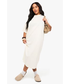 Relaxed oversize fit with a flattering midi length
        Soft knitted fabric for all-day comfort
        Classic crew neckline with short sleeves
        Versatile curved hemline for added style
        Inclusive plus sizing designed to complement your curves
    
    This effortlessly chic T-shirt dress from Boohoo is the ultimate wardrobe staple for the fashion-forward woman. The relaxed silhouette offers both comfort and style, making it perfect for casual daytime outings. Style with trainers and a crossbody bag as shown for a laid-back weekend look, or transform your ensemble with chunky boots and a leather jacket for an edgier vibe. The versatile design works brilliantly for family gatherings or coffee dates with friends. For cooler days, layer with an oversized cardigan or denim jacket and accessorise with statement jewellery to showcase your personal style. The simple yet contemporary design allows for endless styling possibilities, ensuring this dress becomes a go-to piece in your casual collection. Pair with ankle boots and a wide-brimmed hat for a touch of boho flair that's quintessentially British.