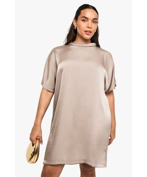 Luxurious satin finish with a subtle sheen that catches the light beautifully
        Oversized silhouette for effortless comfort and contemporary style
        Elegant high neckline adds a sophisticated touch
        Short sleeves with relaxed drop shoulders for a modern look
        Straight-cut hemline that falls above the knee for a flattering finish
    
    Make a statement after dark with this plus size satin t-shirt dress that combines comfort with undeniable glamour. The oversized fit creates a relaxed yet fashion-forward silhouette that's perfect for nights out on the town. Style with strappy heels and a metallic clutch, as shown, for an ensemble that transitions seamlessly from drinks to dancing. The lustrous satin fabric reflects light beautifully, ensuring you'll stand out in any venue. For cooler evenings, layer with a cropped leather jacket and add statement earrings to complete your look. This versatile piece works equally well for impromptu drinks with friends or planned nights at the hottest new club - simply customise your accessories to suit the occasion.
