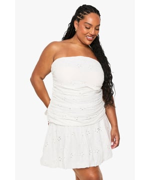 Strapless bandeau neckline with delicate broderie anglaise detailing throughout
        Flattering ruched bodice design that accentuates your curves
        Feminine skater silhouette with a flared skirt for effortless movement
        Versatile cotton blend fabric offering comfort and breathability
        Inclusive plus sizing designed to celebrate every body shape
    
    This charming Plus Bandeau Broderie Skater Dress from Boohoo combines casual comfort with feminine flair. The intricate broderie anglaise pattern adds texture and visual interest, while the ruched bodice creates a figure-enhancing effect. Perfect for summer gatherings, pair with simple white trainers and a denim jacket for daytime brunches, or dress up with strappy sandals and statement earrings for evening garden parties. The strapless design showcases your shoulders beautifully, making it ideal for warm-weather occasions. For family gatherings, style with a lightweight cardigan and flat sandals for an effortlessly chic ensemble. This versatile dress transitions seamlessly from casual daytime events to relaxed evening outings - simply customise your look with the right accessories to suit any occasion.