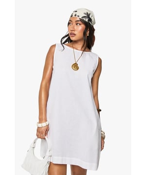 Sleeveless linen-mix mini dress with a classic crew neckline
        Relaxed, straight-cut silhouette that offers effortless movement
        Elegant open back detail adding a subtle statement element
        Mini length perfect for showcasing your favourite summer footwear
        Versatile design suitable for layering with seasonal accessories
    
    This breezy linen-mix mini dress from Boohoo captures the essence of carefree summer style. The clean lines and minimalist design create a canvas for your personal styling touches. Pair with flat sandals and a patterned headscarf as shown for daytime outings, or dress it up with layered bangles and a statement pendant necklace for casual gatherings. The open back detail adds an unexpected twist to this otherwise simple silhouette. For cooler evenings, layer with a lightweight denim jacket and switch to espadrilles. This dress transitions seamlessly from beach days to family barbecues, and works brilliantly for city exploring or countryside jaunts. The breathable fabric makes it an ideal choice for warm-weather occasions when comfort and style are equally important.