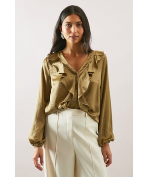 Elegant satin blouse featuring a striking cascading ruffle detail along the V-neckline
        Sophisticated long sleeves with gentle gathering at the cuffs for a feminine silhouette
        Flattering V-neckline that frames the dcolletage beautifully
        Versatile button-through front design for adjustable styling options
        Relaxed fit through the body offering both comfort and elegance
    
    This sumptuous satin blouse radiates sophistication with its eye-catching ruffle detail cascading from the V-neckline. Perfect for special occasions, it pairs wonderfully with tailored wide-leg trousers as shown for a refined ensemble that commands attention at formal events. The lustrous fabric catches the light beautifully, whilst the relaxed silhouette ensures you remain comfortable throughout your event. For wedding guest attire, style with a sleek pencil skirt and delicate jewellery, or dress down for evening drinks by tucking into high-waisted jeans with statement earrings. The hotfix embellishment adds a subtle touch of glamour that transitions effortlessly from day to night, making this blouse a versatile addition to your occasion wardrobe. A true Wallis classic that combines timeless elegance with contemporary design.