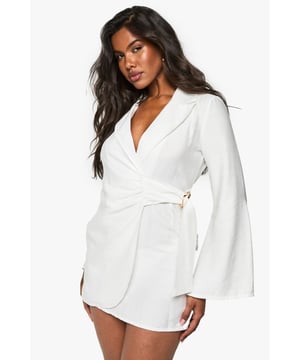 Tailored blazer dress with wrap neckline
        Linen-look fabric for a textured appearance
        Buckle detail adds a touch of sophistication
        Tie waist for a flattering silhouette
        Long sleeves with a structured shoulder
    
    Make a statement in this chic linen-look blazer dress, perfect for those nights out when you want to turn heads. The wrap neckline and tie waist create a figure-hugging silhouette that's both flattering and comfortable. The buckle detail adds an element of intrigue, while the tailored structure gives a polished look. Style it with strappy heels and statement earrings for a night at the club, or dress it down with white trainers for drinks with friends. The versatility of this piece makes it a wardrobe essential for the fashion-forward woman who values both style and comfort. Whether you're dancing the night away or enjoying cocktails at a rooftop bar, this blazer dress is sure to keep you looking effortlessly stylish.