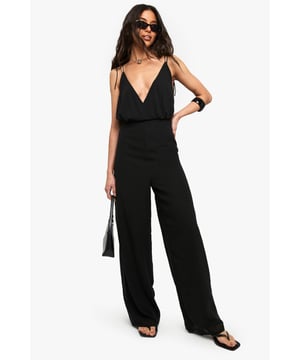 Flowing chiffon fabric with elegant drape for effortless movement
        Striking plunging V-neckline with delicate adjustable spaghetti straps
        Wide leg silhouette creates a dramatic, floor-sweeping effect
        Elasticated waistband offers comfortable fit whilst defining your shape
        Fully lined design ensures opacity and smooth wear
    
    Make a statement after dark in this captivating wide leg jumpsuit. The fluid chiffon fabric creates a graceful silhouette that moves beautifully with every step, whilst the deep V-neckline adds a touch of allure. Style with strappy heels and statement jewellery for cocktail parties or club nights - the minimalist design serves as the perfect canvas for bold accessories. For cooler evenings, layer with a cropped jacket or tailored blazer. The wide leg cut elongates your frame, creating a sophisticated yet contemporary look that transitions seamlessly from dinner dates to dancing. This versatile Boohoo piece works equally well with sleek, pulled-back hair to showcase the neckline or loose waves for a more relaxed vibe.