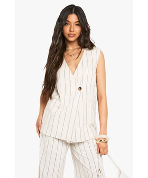 Sleeveless wrap vest with distinctive pinstripe pattern
        Boxy fit design for a relaxed, contemporary silhouette
        Single statement button fastening for effortless style
        Practical side pockets for added functionality
        Linen-look fabric offering breathable comfort for warmer days
    
    This versatile wrap vest brings a touch of tailored sophistication to your casual wardrobe. The boxy silhouette creates a relaxed yet structured look that pairs beautifully with the coordinating wide-leg trousers as shown, or can be styled with your favourite denim for an effortlessly chic ensemble. The linen-look fabric offers a textured finish that works wonderfully for family gatherings, brunches with friends, or casual office settings. Layer with a lightweight turtleneck during transitional seasons or wear alone with delicate layered jewellery for summer outings. Complete the look with minimal accessories and flat sandals for daytime events, or dress up with statement earrings and heeled mules for evening socials. This Boohoo piece embodies casual refinement that transitions seamlessly from day to night.