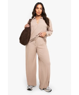 Ribbed texture for added comfort and visual interest
        Collared neckline with open V-front for a relaxed yet polished look
        Wide-leg trousers with flowing silhouette for unrestricted movement
        Long sleeves with comfortable cuffed finish
        Coordinated two-piece set for effortless styling
    
    This sophisticated loungewear set from Boohoo combines comfort with contemporary style. The ribbed collared top features a flattering V-neckline that adds a touch of refinement to your at-home wardrobe, while the wide-leg trousers create a fluid silhouette that moves beautifully with you. Perfect for those lazy Sunday mornings with a coffee and magazine, yet smart enough for impromptu video calls or welcoming unexpected visitors. Style with trainers as seen on our model for quick errands, or swap for plush slippers when embracing total relaxation. The versatile design works wonderfully layered with an oversized cardigan when temperatures drop, or simply on its own for warmer days. This set represents the ultimate balance between comfort and put-together style for the fashion-conscious homebody.